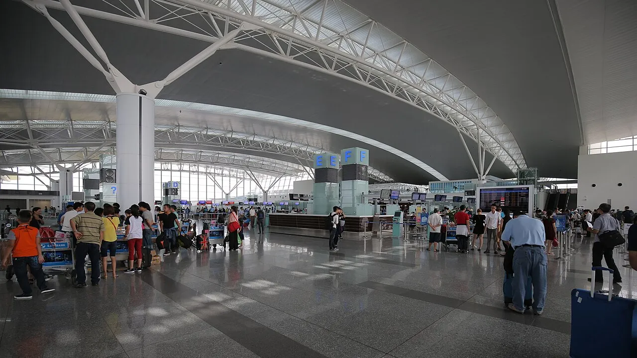 Voyageurs avec valises et chariots dans le hall d'enregistrement du terminal 2 de l'aéroport international de Nội Bài, à Hanoï
