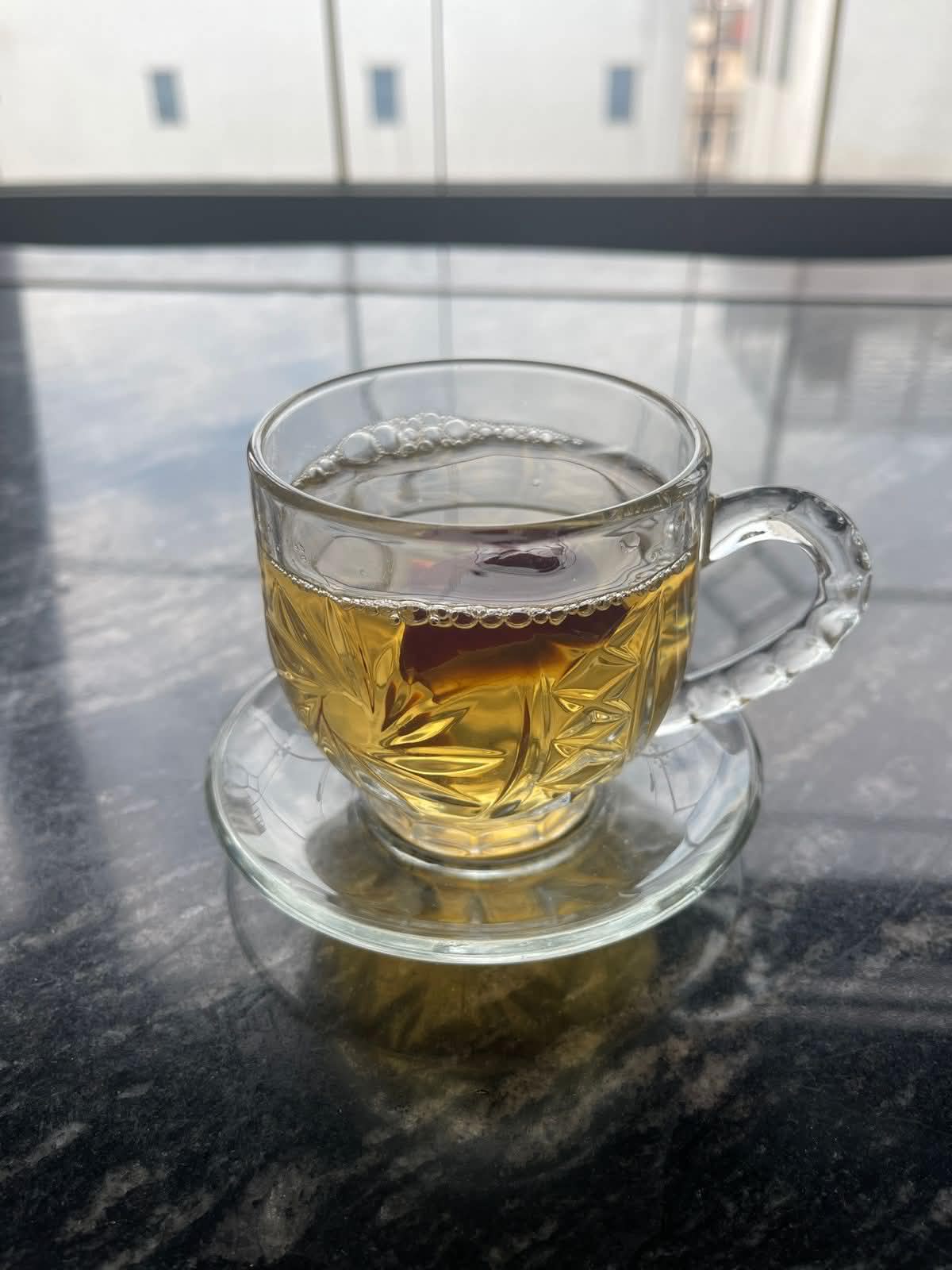Verres de thé ambré posés sur un tissu vert, ambiance chaleureuse