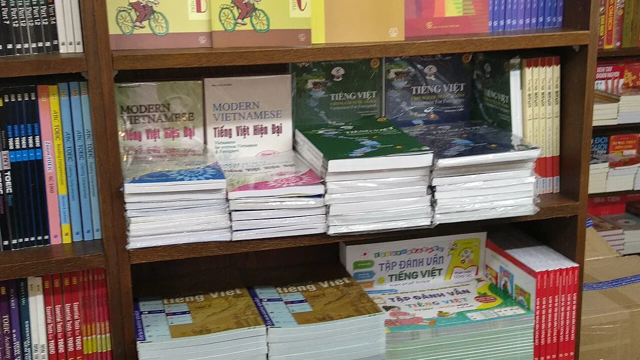 Rayonnage de librairie rempli de manuels de vietnamien pour étrangers, dont plusieurs volumes Tiếng Việt 123 et Thực hành tiếng Việt