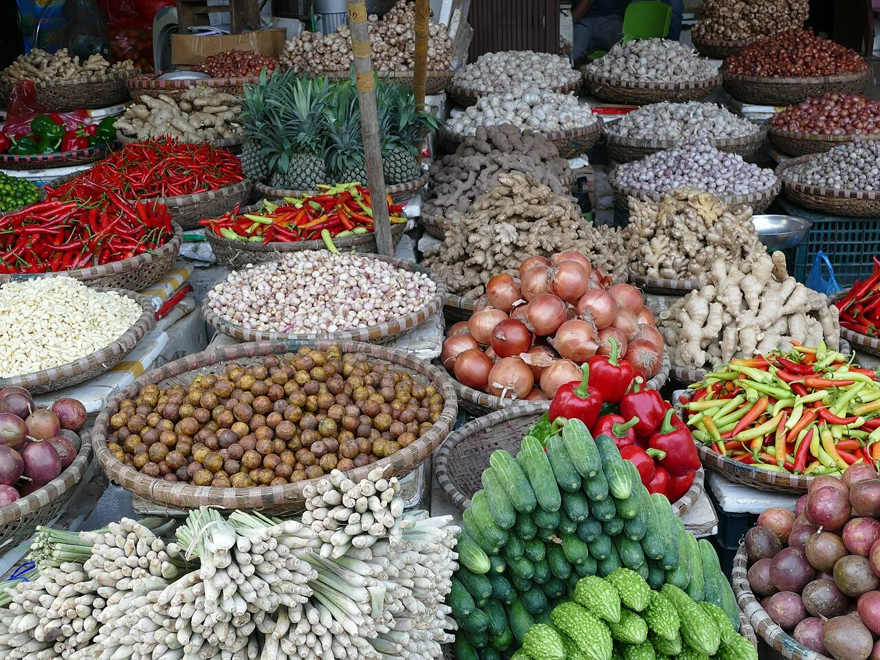 Paniers de piments, oignons, gingembre, citronnelle et concombres sur un étal de marché à Hanoï