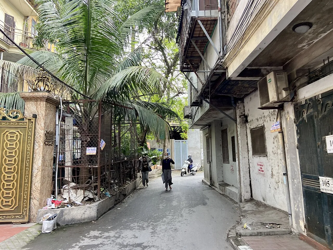 Ruelle résidentielle étroite bordée de maisons, de climatiseurs et d'un palmier, au ngõ 198 de la rue Xã Đàn à Hanoï