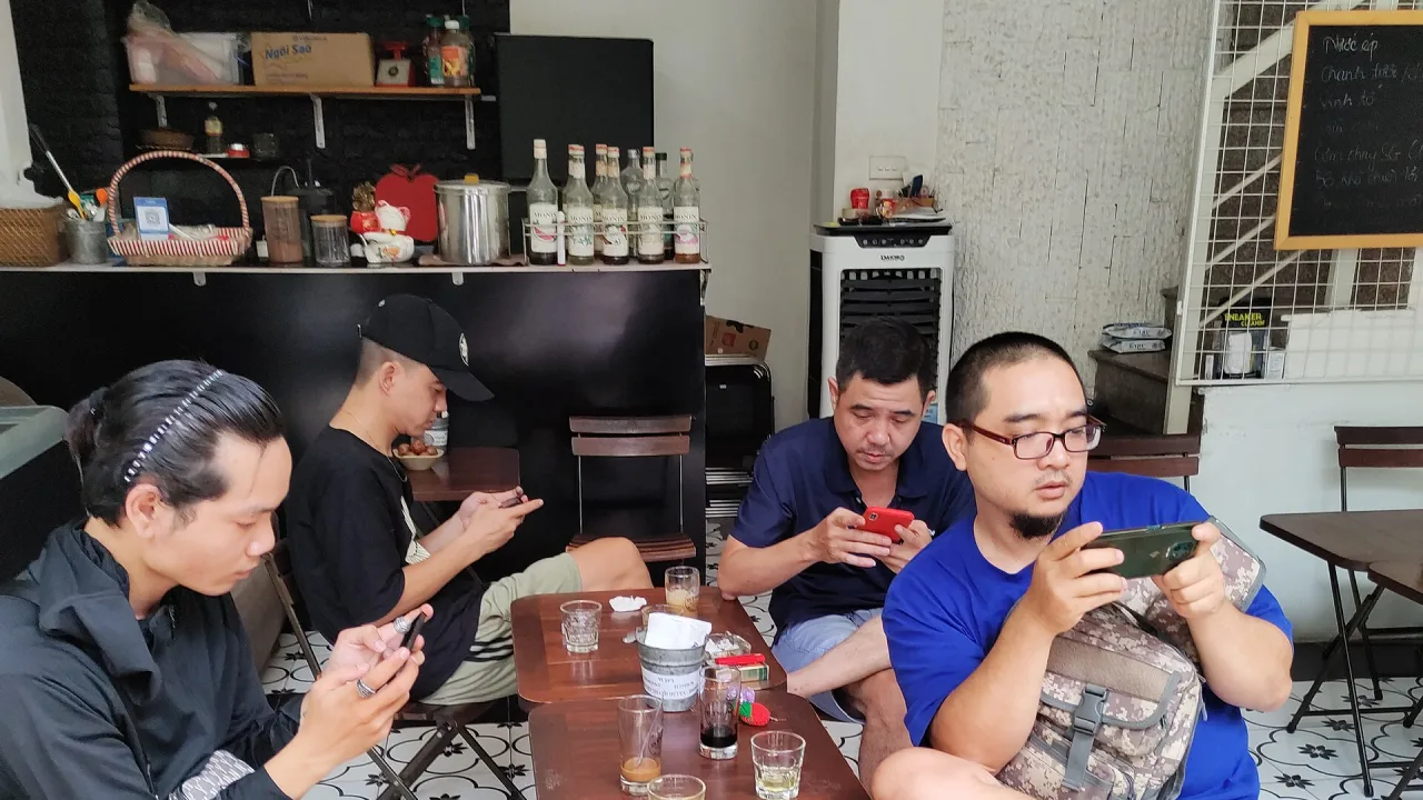 Des personnes consultant leur téléphone dans un café à Hanoï