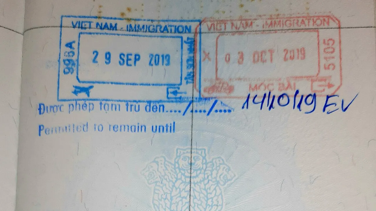Page de passeport avec un tampon d'entrée bleu de l'immigration vietnamienne portant la mention « Permitted to remain until » complétée à la main, et un tampon de sortie rouge